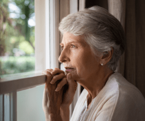 Elderly woman looking out of the window