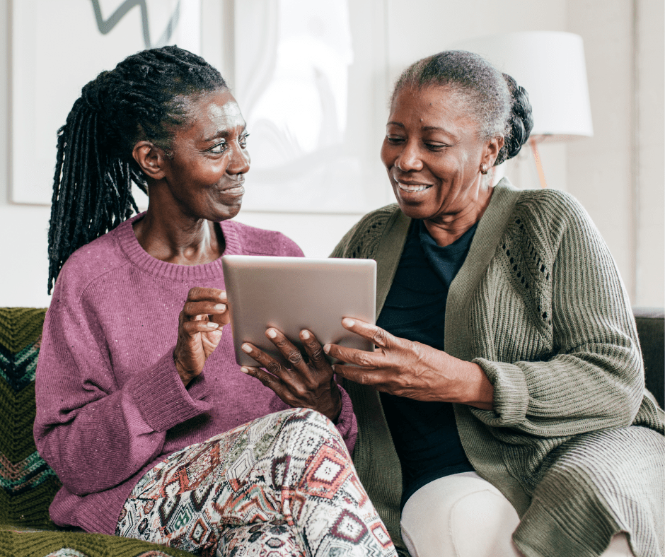 Adult daughter and senior mother looking at a tablet