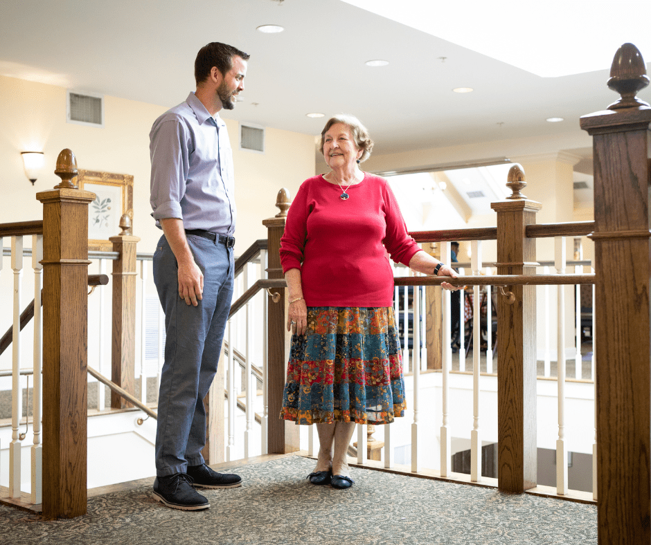 Resident and employee smiling in conversation
