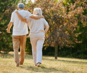 Senior couple walking with arms around each other