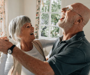 Senior couple dancing and laughing in kitchen