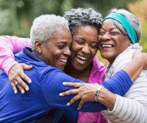 Group of three women hugging and smiling